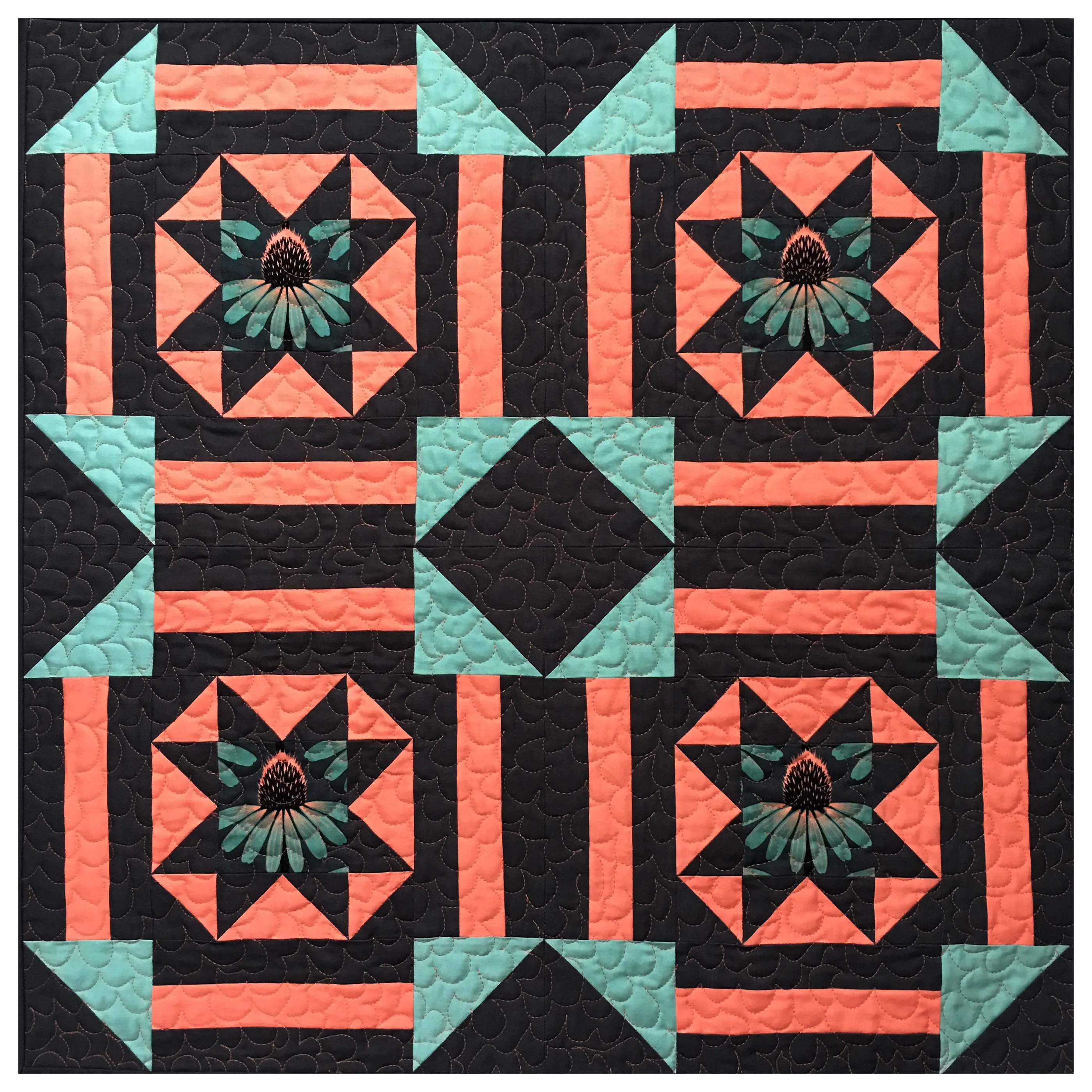 A symmetrical patchwork quilt with coral, teal and black star blocks featuring embroidered flower centers, bold graphic colors, bright and airy mood
